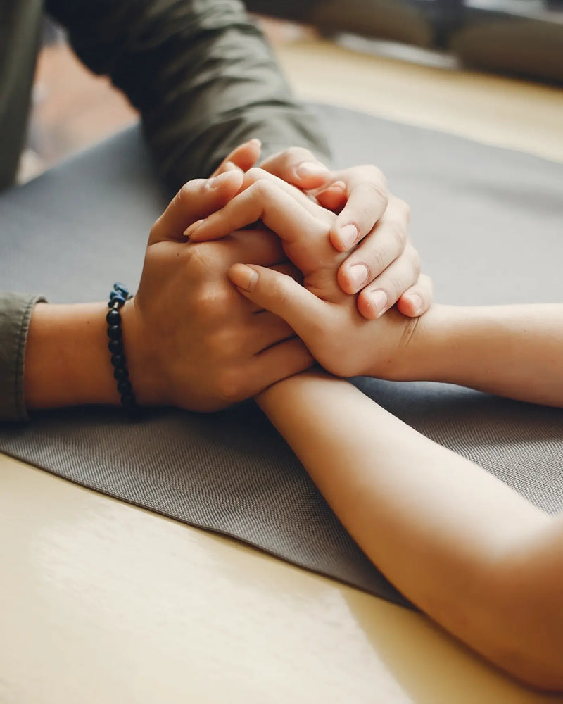 men and women holding hands on table